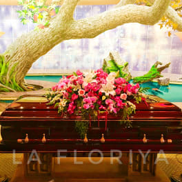 Pink and white floral spray on a dark casket