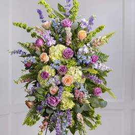 Tall standing floral spray with roses, hydrangeas, and purple blooms