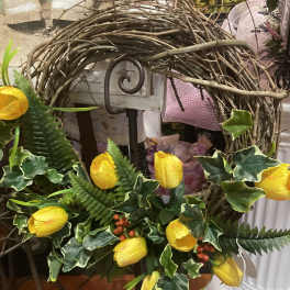Yellow tulips arranged with ivy in a twig wreath