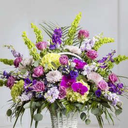 Large basket arrangement of purple, pink, and white flowers