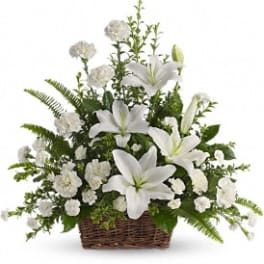 White lilies and small white blooms in a wicker basket