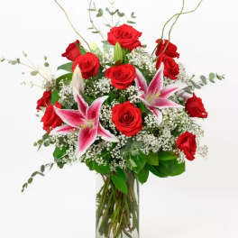 Red roses and pink lilies in a clear glass vase