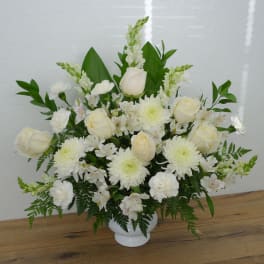 White roses and chrysanthemums arranged in a white vase