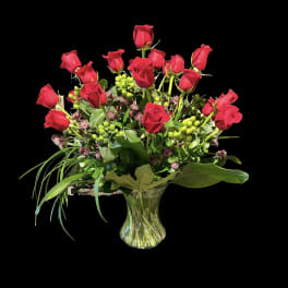 Red roses arranged in a clear glass vase