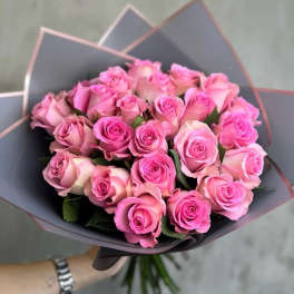 Bouquet of pink roses wrapped in dark paper