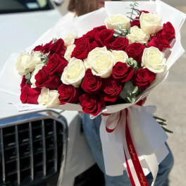 Bouquet of red and white roses wrapped in white paper