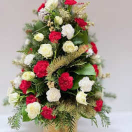Cone-shaped floral arrangement with red and white blooms in a gold container