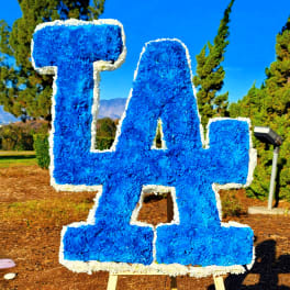 Large blue floral "LA" sign on an easel outdoors
