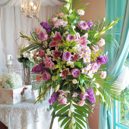 Large pink and purple floral arrangement on a stand