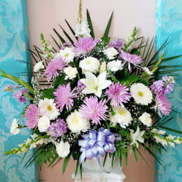 Large bouquet of white and lavender flowers with a ribbon bow