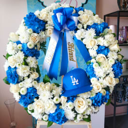 Blue and white floral wreath with ribbons and a baseball cap