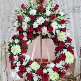 Large red and white floral wreath on an easel