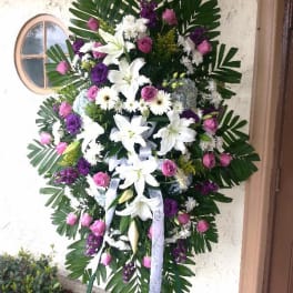 Standing floral spray with white lilies, pink roses, and purple accents