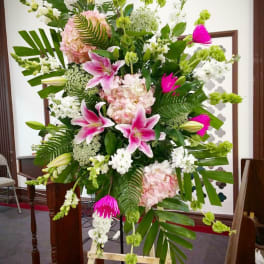 Tall standing floral spray with pink lilies, white blooms, and green accents