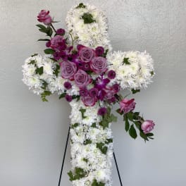 Cross-shaped floral tribute with white chrysanthemums and pink roses