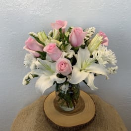 Pink roses and white lilies arranged in a glass vase