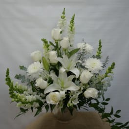 White floral arrangement with roses, lilies, and chrysanthemums in a vase
