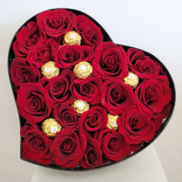 Heart-shaped box filled with red roses and gold-wrapped chocolates