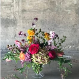 Mixed bouquet with pink and purple flowers in a clear glass vase