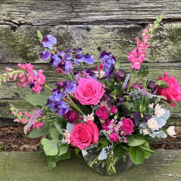 Pink and purple mixed flower arrangement in a glass vase