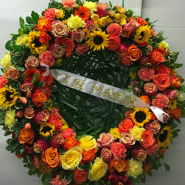 Large floral wreath with a white ribbon reading "OUR MAYOR"