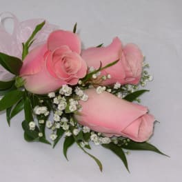 Pink rose corsage with baby's breath and ribbon