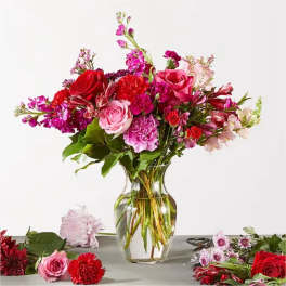 Mixed pink and red flower bouquet in a clear glass vase