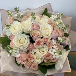 Large bouquet of cream and blush roses with white filler flowers