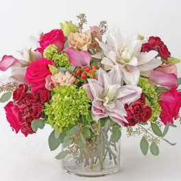 Mixed bouquet of pink and white flowers in a clear glass vase