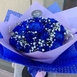 Bouquet of vivid blue roses with white baby's breath in lavender and blue wrap