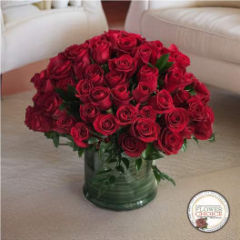 Red roses arranged in a green glass vase