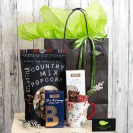 Gift basket with popcorn, chocolates, and a floral mug