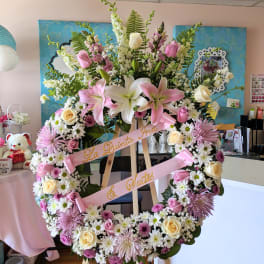 Large floral wreath on an easel with pink and white flowers