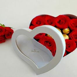 Red roses in a heart-shaped gift box with gold chocolates