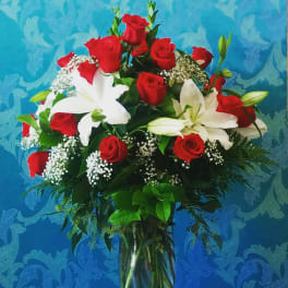 Bouquet of red roses and white lilies in a glass vase