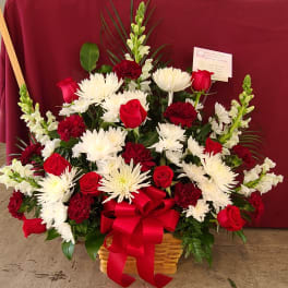 Red roses and white chrysanthemums in a basket with a red bow