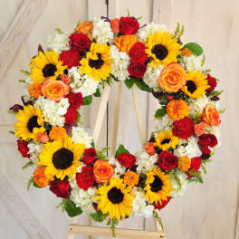 Heart-shaped floral wreath with sunflowers, roses, and white blooms