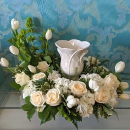 White floral arrangement with roses and tulips in a white vase