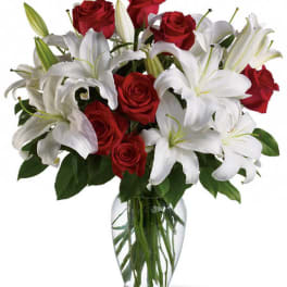 Red roses and white lilies in a clear glass vase