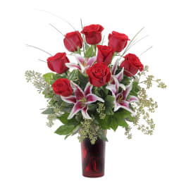 Red roses and pink lilies in a red glass vase