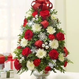 Christmas tree-shaped bouquet of red roses and white flowers in a vase