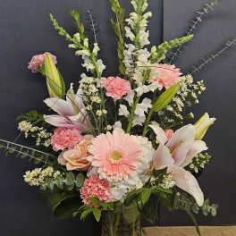 Pink and white mixed flower arrangement in a glass vase