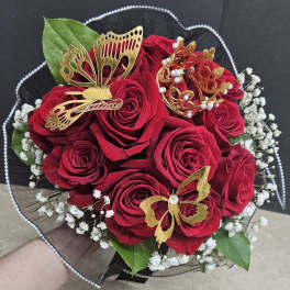 Bouquet of red roses with gold butterfly decorations and white filler flowers