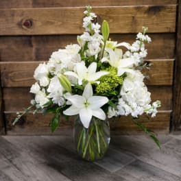 White lilies and roses arranged in a glass vase