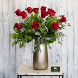 Red roses arranged in a tall metallic vase