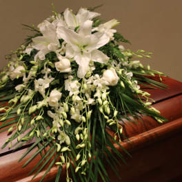 White floral spray on a wooden casket