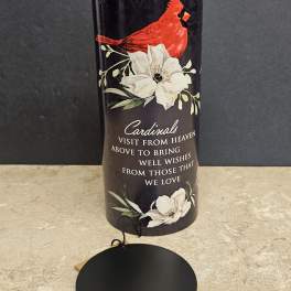 Black memorial candle holder with a red cardinal and white flowers
