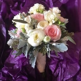 Bouquet of pink and white flowers wrapped in purple paper