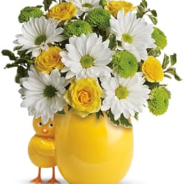 Yellow vase with daisies and roses, plus a small chick figurine