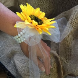 Yellow sunflower wrist corsage with white tulle and pearl bracelet